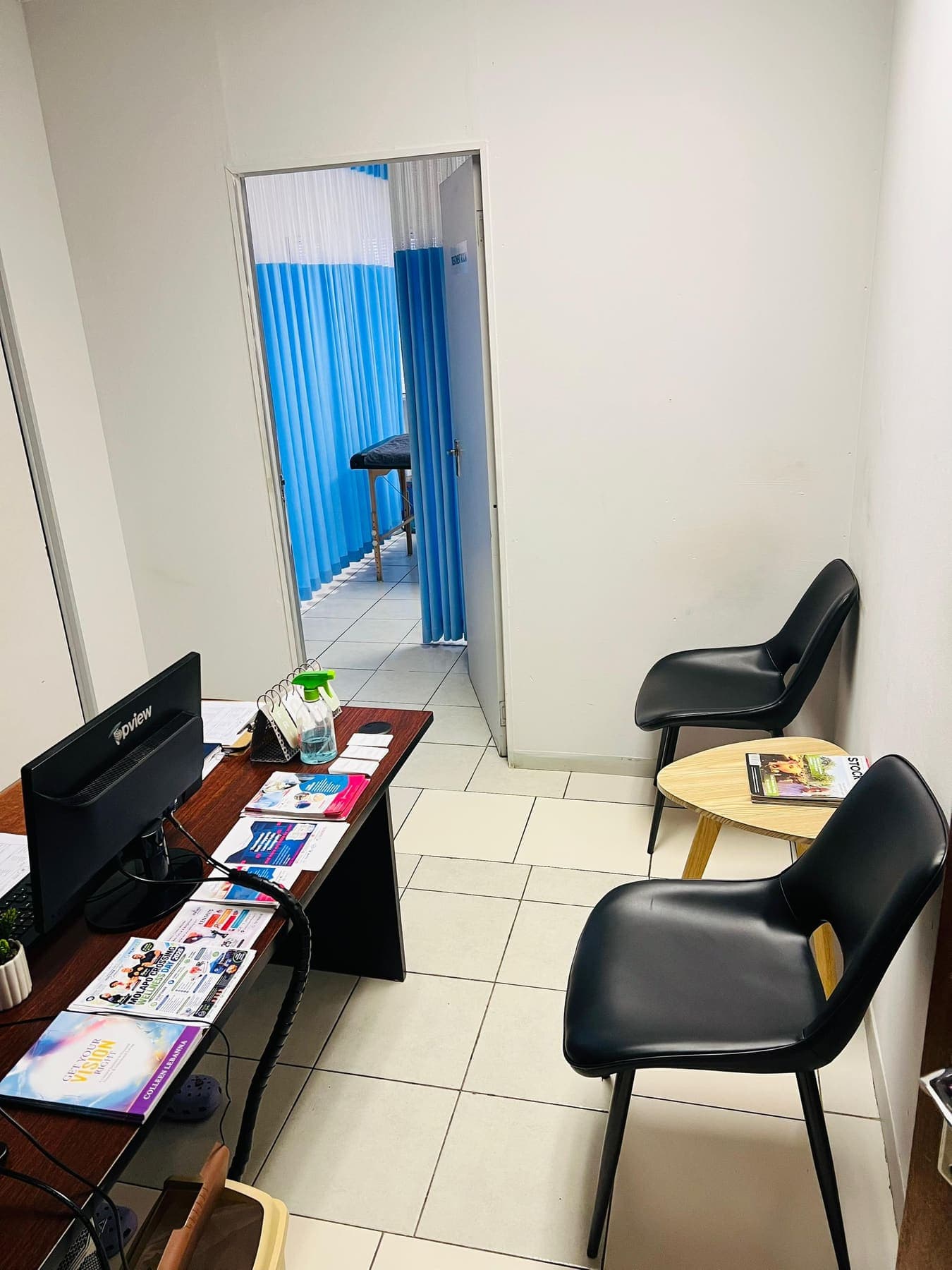 Reception at the Grace Physiotherapy Molapo Crossing clinic, with the desk on the left and the curtained treatment area beyond.
