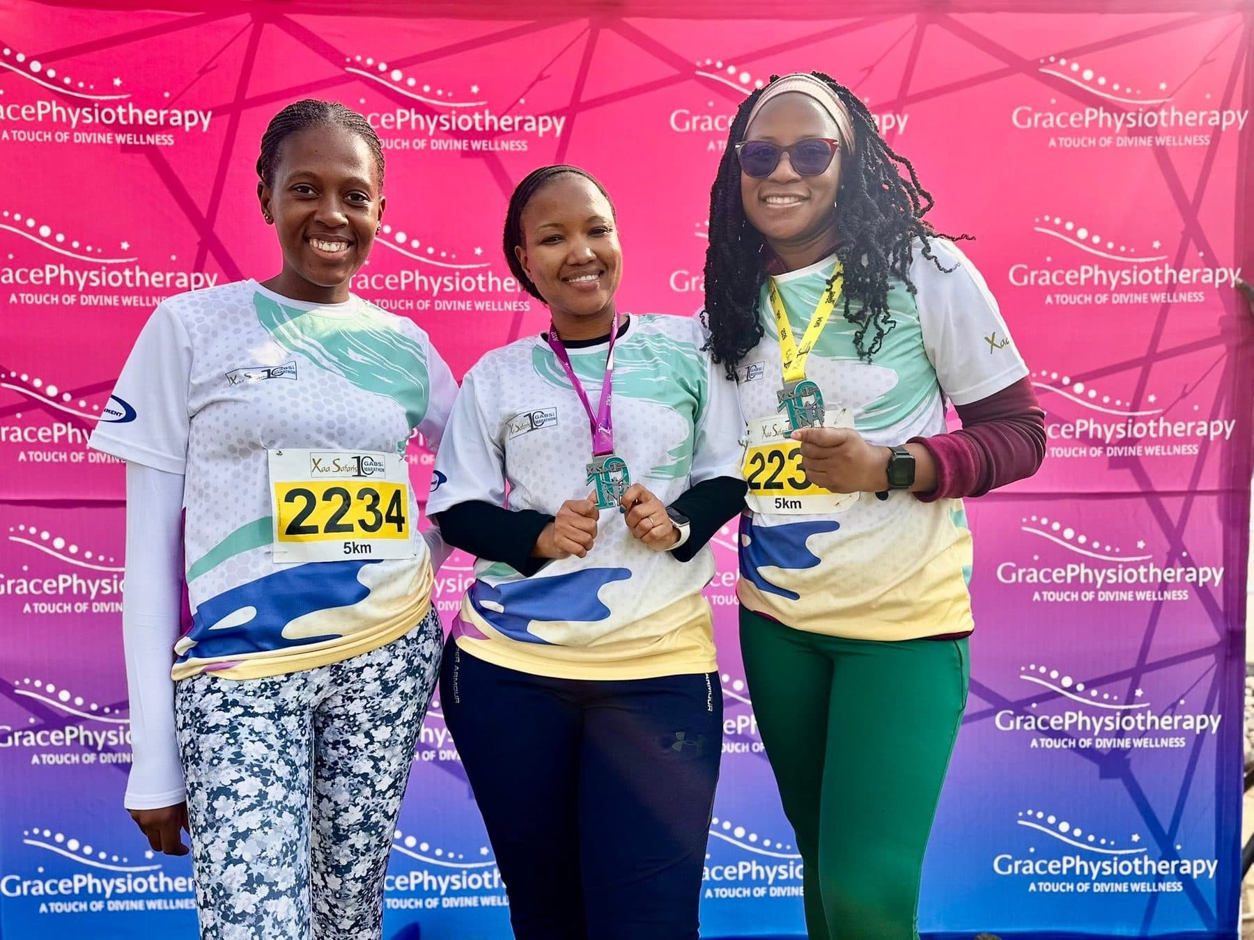 Grace Physiotherapy team members in branded kit at a race day recovery station.