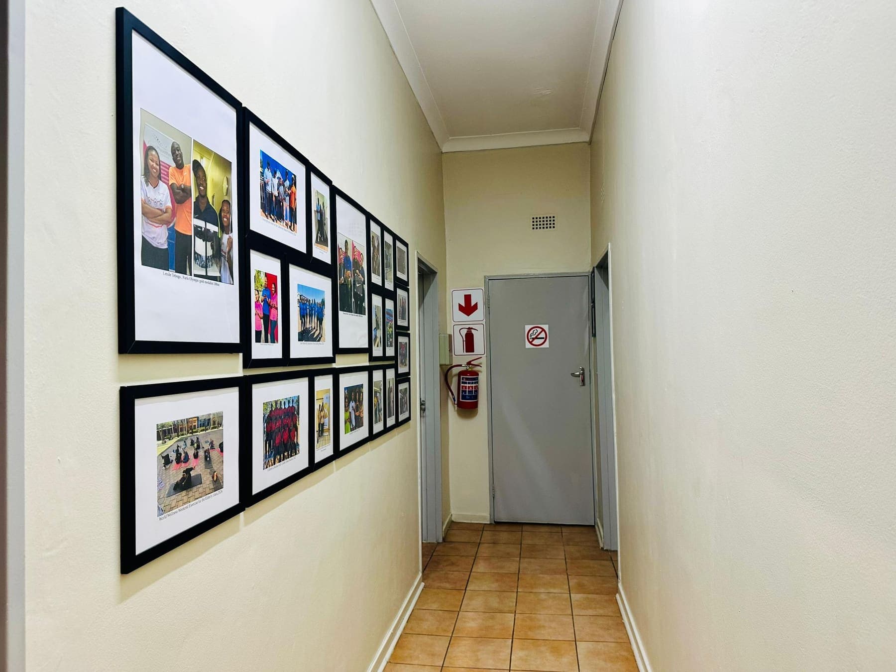 The African Mall corridor lined with framed photographs from Grace Physiotherapy community events and race days.