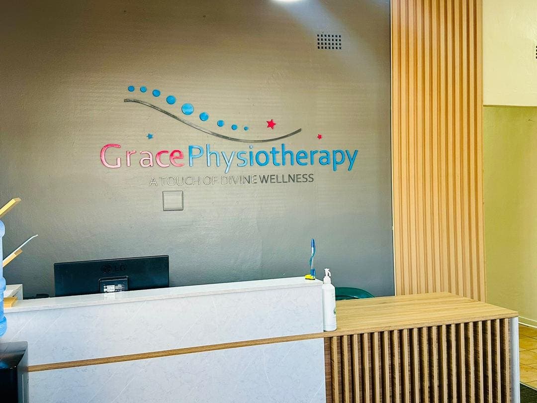 The African Mall reception desk beneath the Grace Physiotherapy logo wall reading A Touch of Divine Wellness.